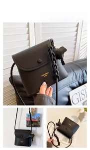 Detail of black lychee grain PU leather bucket bag with braided handle and elephant charm