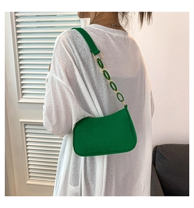 Detail of green crescent shoulder bag with matte texture and gold oval chain strap link