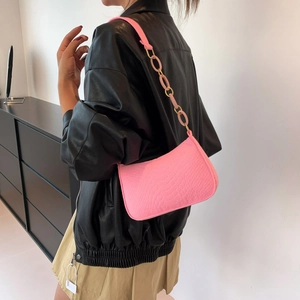 Pink faux crocodile leather baguette shoulder bag with chain strap on female model