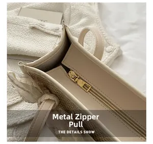 Detail of cream woven tote bag with smooth gold zipper and white lace bow decoration