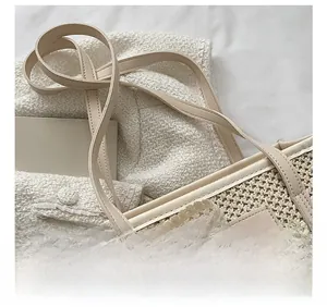 Close-up of beige woven bucket bag featuring delicate lace floral bow and leather strap
