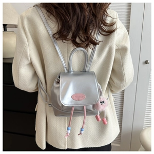 Silver mini backpack detail with pink monster charm and logo for stylish women