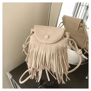 Détail du sac bandoulière en daim beige avec de longues franges et un anneau doré