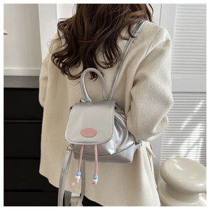 Detail of silver metallic backpack featuring pink drawstring and Pautor logo