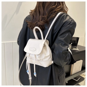 Detail of a creamy white mini backpack with PALITOR logo and blue bead drawstring