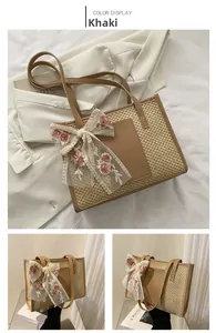 Close-up of khaki straw tote bag with floral lace bow and premium brown PU leather patch