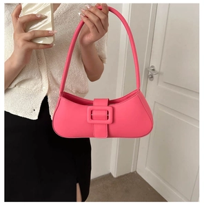 Close-up of rose red underarm bag with large square buckle and smooth leather texture
