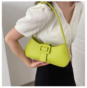 Chic avocado green baguette bag with decorative buckle shown as a crossbody shoulder style