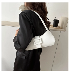 Chic white leather shoulder bag with a large square buckle detail on a female model