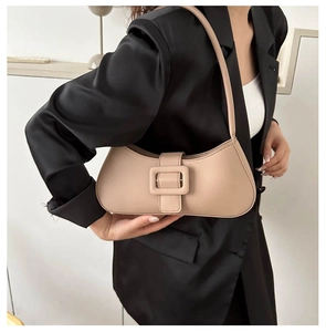 Chic beige half-moon underarm bag with decorative buckle on black satin blazer