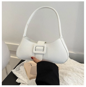 Close-up of white minimalist baguette bag featuring a large rectangular buckle detail
