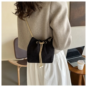 Detail der schwarzen Cord-Beuteltasche mit Perlen-Kordelzug und goldener Kette