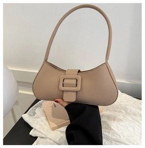 Detail of minimalist beige baguette shoulder bag with a large square decorative buckle