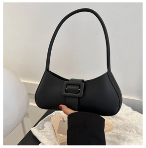 Detail of a black matte leather baguette bag with a square buckle and slim strap