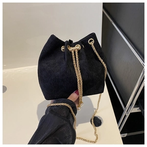 Detail der schwarzen Cord-Beuteltasche mit Goldkette und Kordelzug mit Perlenanhänger