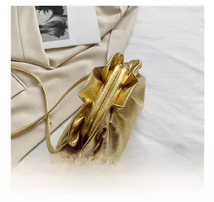 Detail showing the pleated opening and metallic gold finish of the soft cloud bag