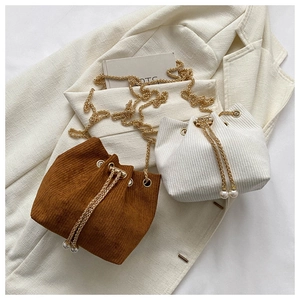 Detail der Cord-Beuteltasche mit Kordelzug, goldener Kette und Perlenanhängern
