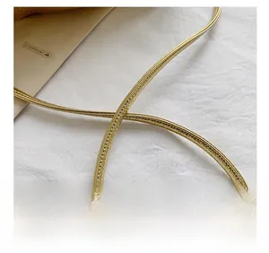 Detail of the golden soft faux leather shoulder strap with fine stitching on cloud bag