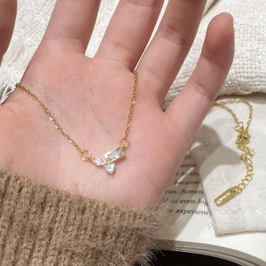 Gold-plated necklace with sparkling irregular zircon pendants shown in a hand close-up
