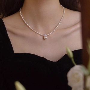 Elegant pearl and zircon pendant necklace with gold plating on a model in close-up