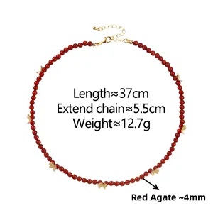 Détail du collier en agate rouge avec papillons dorés et fermoir mousqueton poli