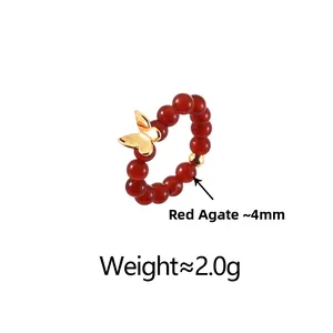 Détail d'une bague en perles d'agate rouge avec papillon doré et mesures de poids
