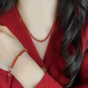 Ensemble collier et bracelet en agate rouge avec breloques papillon dorées sur mannequin