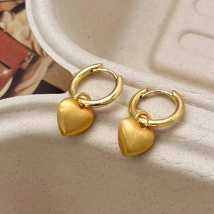 Eleganti orecchini a cerchio con cuore d'oro e finitura opaca spazzolata su espositore morbido