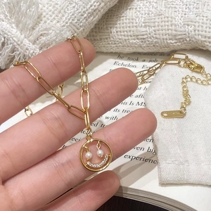 Collier sourire doré avec perles et zircons sur une chaîne à maillons longs