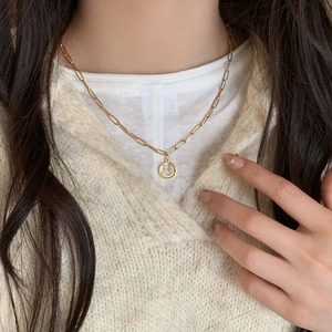 Collier doré avec pendentif sourire perles et zircons sur une chaîne trombone élégante