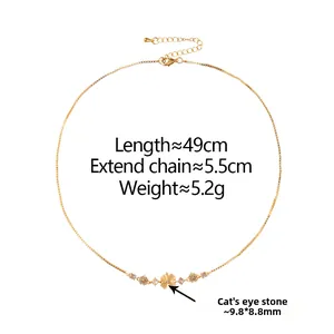 Close-up of golden floral necklace with cat's eye stone charms and adjustable chain link