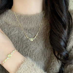 Elegant gold clover jewelry set with cat eye stones and cubic zirconia on model