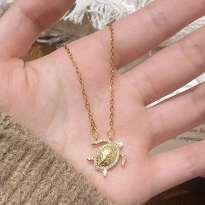 Golden sea turtle pendant necklace with sparkling cubic zirconia on a delicate chain