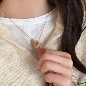 Exquisite gold turtle pendant necklace with zircon embellishment worn by a model
