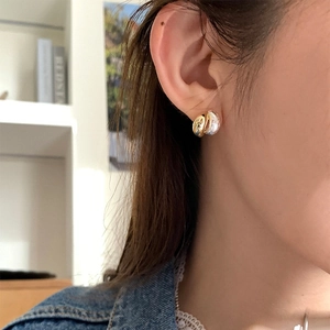 Detail of two-tone gold and silver earrings with hammered texture on female model
