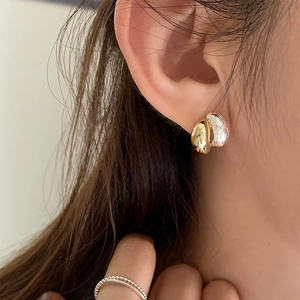 Elegant two-tone gold and silver minimalist metal stud earrings shown on model