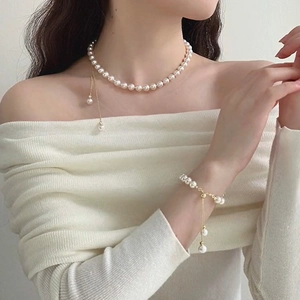 Elegant white pearl necklace and bracelet set with gold fringe pendant on model
