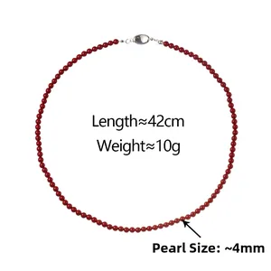 Macro detail of a 42cm red pearl necklace with a 4mm diameter and a silver metallic clasp
