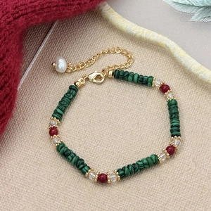 Detail of red and green beaded necklace set with freshwater pearl and golden clasp