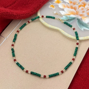 Oriental style necklace with green malachite, red beads and pearls on elegant background