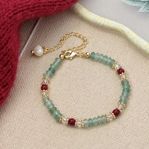 Detailed close-up of handmade beaded bracelet with green jade and red agate gemstones
