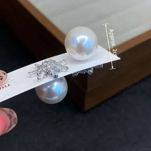 Detail of 2cm snowflake pearl earrings featuring zircon accents and double-sided design