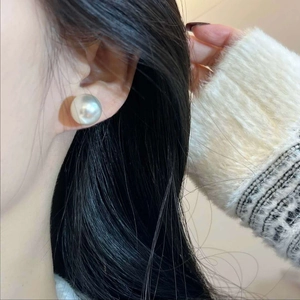 Elegant large white pearl stud earrings on model featuring a minimalist zircon design