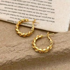 Macro view of gold twisted hoop earrings with textured vintage aesthetic and secure clasp