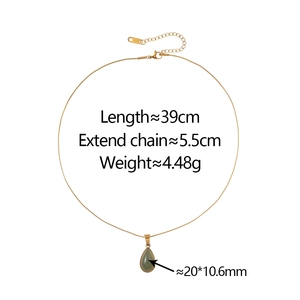 Close-up of golden teardrop necklace with green pendant and lobster clasp details