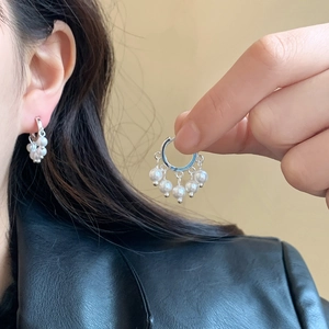 Boucles d'oreilles créoles argentées avec cinq perles pendantes portées par un mannequin