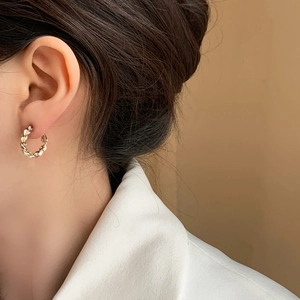 Elegant gold twisted hoop earrings with textured geometric design for a modern style