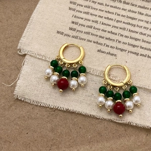 Gros plan détaillé de boucles d'oreilles vintage avec agate verte et perles sur toile