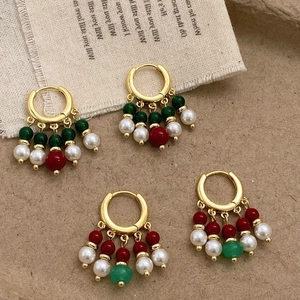 Boucles d'oreilles pendantes rétro avec agate verte et perles sur fond de tissu vintage