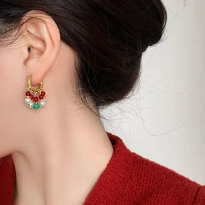 Boucles d'oreilles pompon ethniques avec agate rouge, perles et calcédoine verte sur modèle